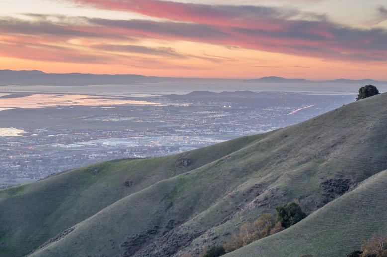 The Healthiest Cities in the United States for Families - Panoramic view of Sunnyvale, CA from a mountain top against a pink sky. 