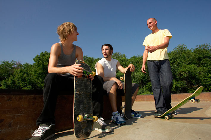 The Healthiest Cities in the United States for Families - Three young men waiting to skate board on a sunny blue skied day in Overland Park, Kansas. 