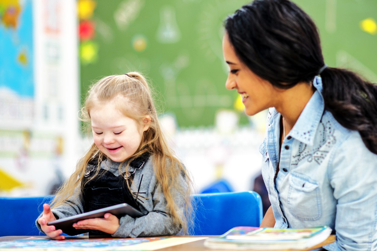 Teacher with down syndrome student who is using a tablet
