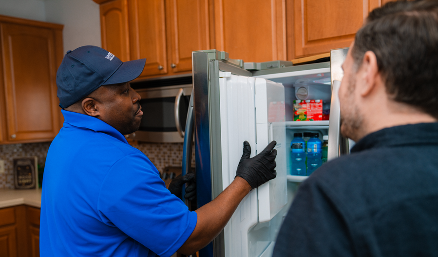 Sears technician fixing a fridge