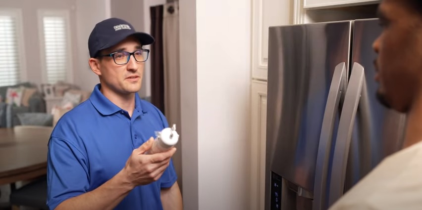 Image of a Sears Tech performing appliance maintenance