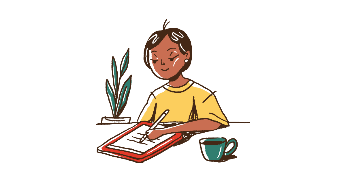 A person in a yellow T-shirt sitting down with a cup of tea writing a letter