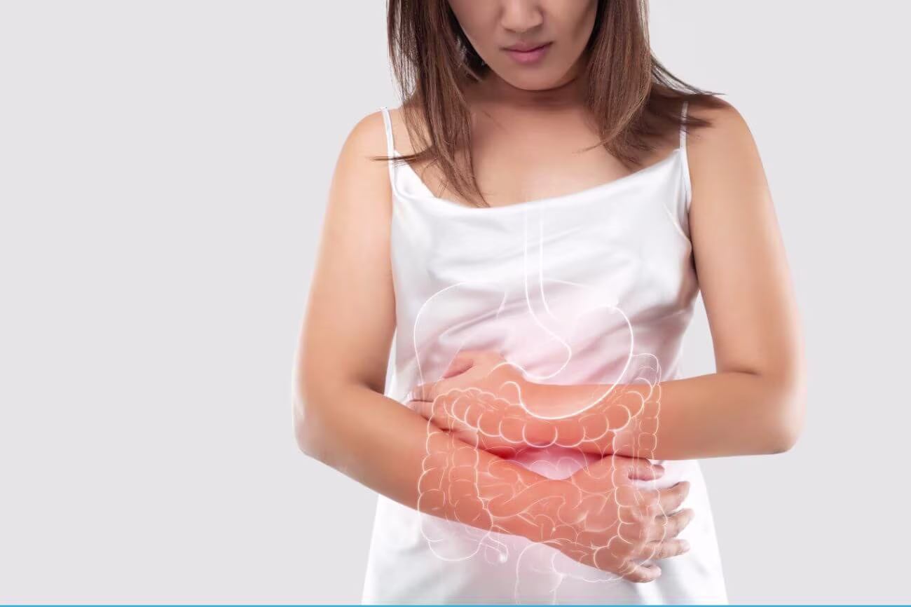 A women holding her stomach in discomfort and illustration of stomach and intestine.