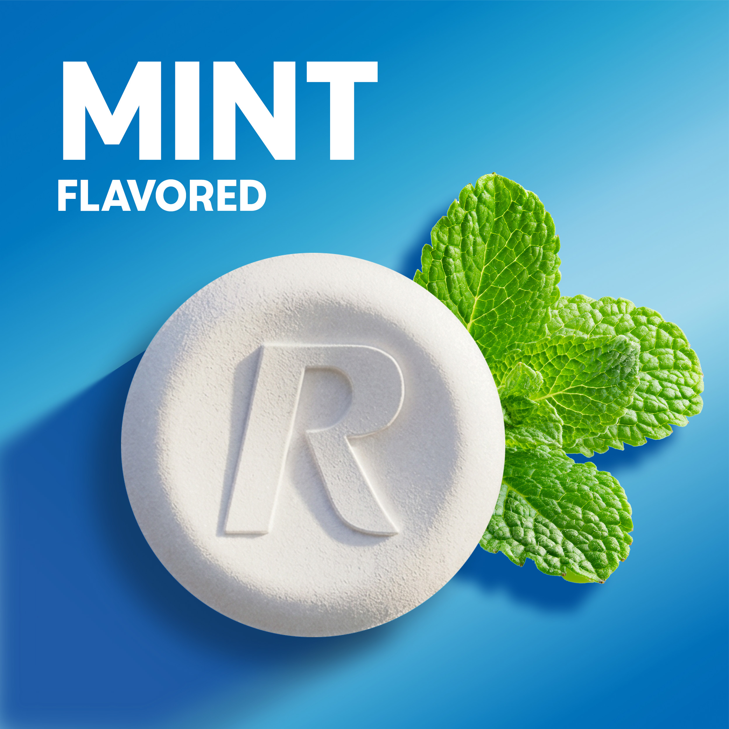 Close-up of a white chewable tablet stamped with an "R" next to fresh mint leaves with "Mint Flavored" text.