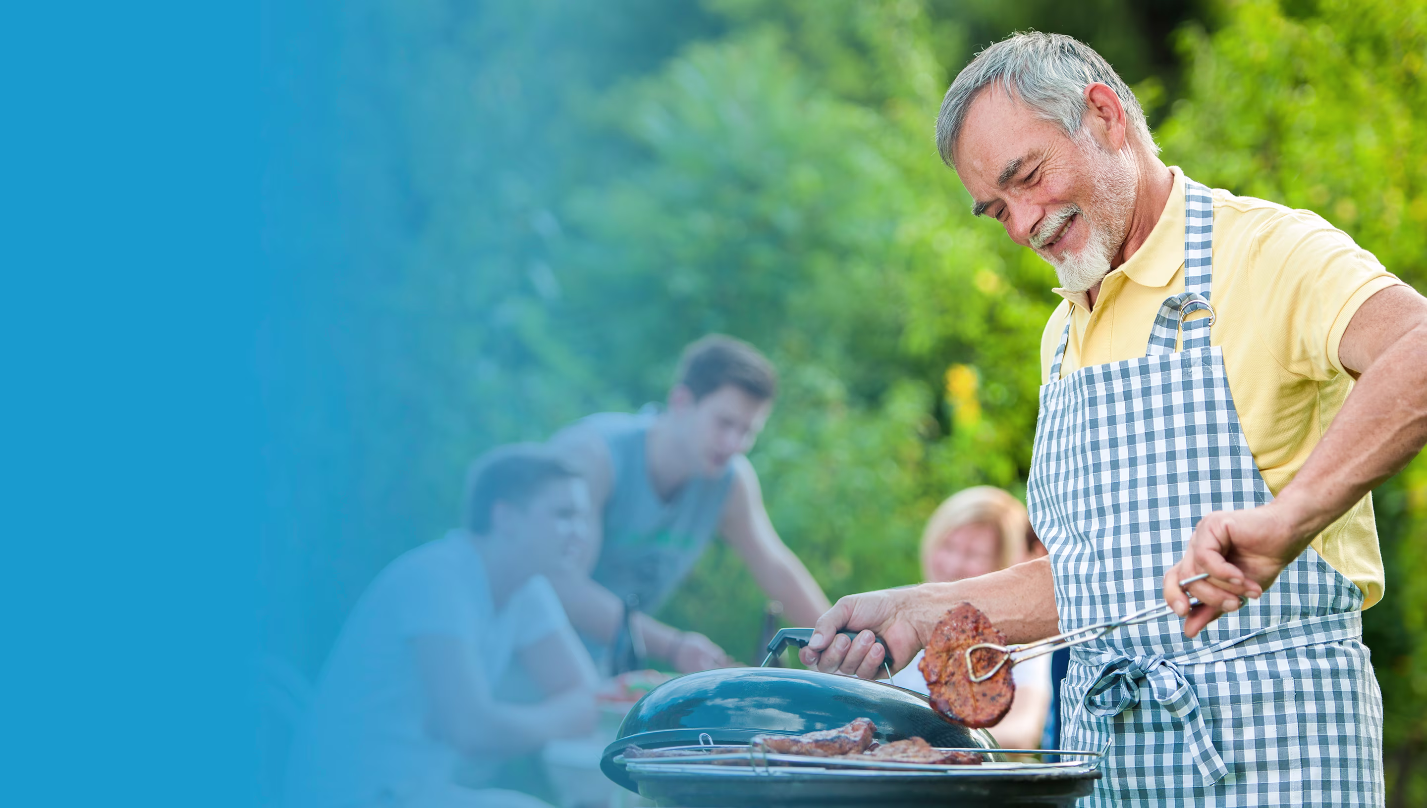 A man cooking on a grill outdoors and people having food at the background.