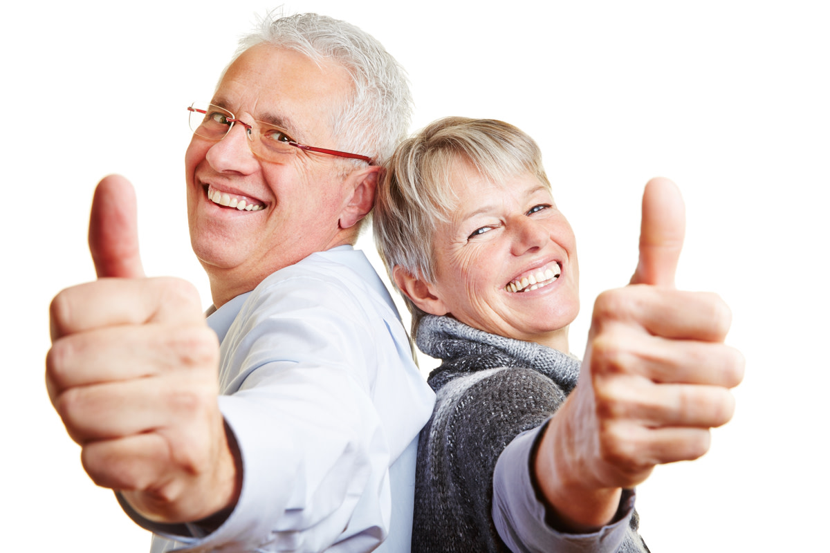 senior couple holding their thumbs up