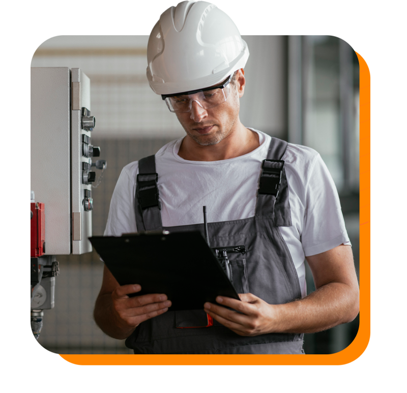 Man with hardhat looking at a clipboard on a job site