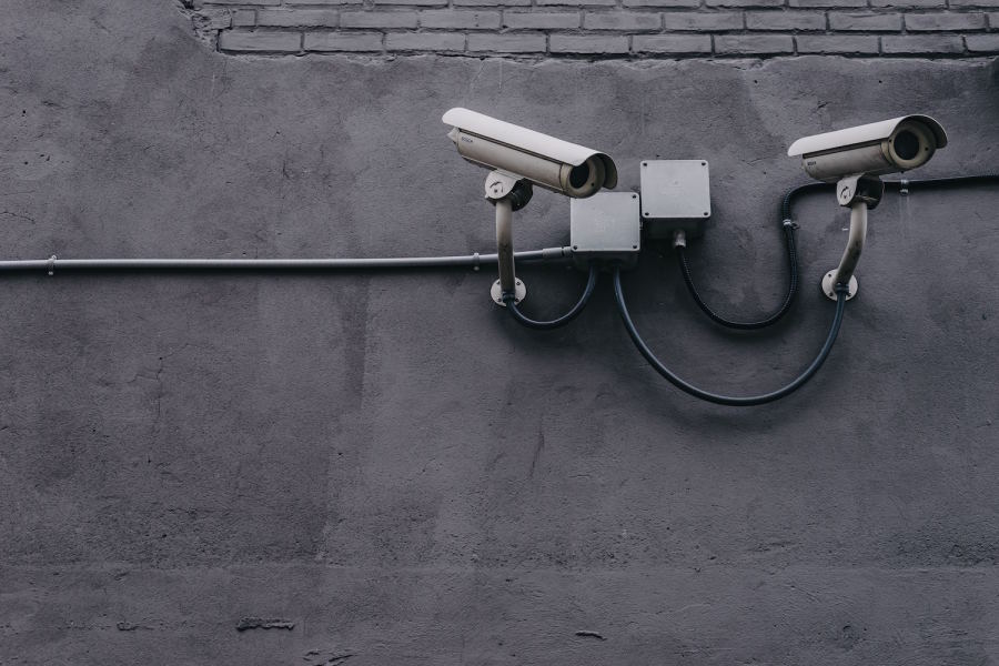 A photo of two security cameras attached to a wall.