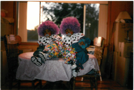 A photo of two young children dressed and made up as clowns.