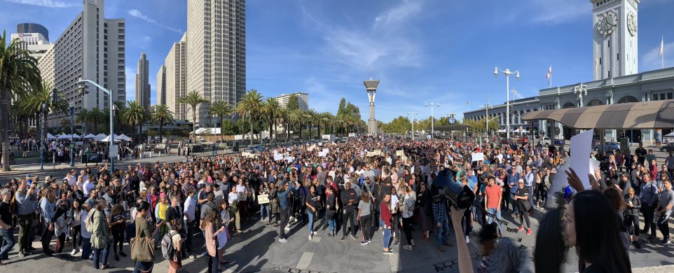 A crowd of hundreds of people in front of San Francisco's Ferry Building.