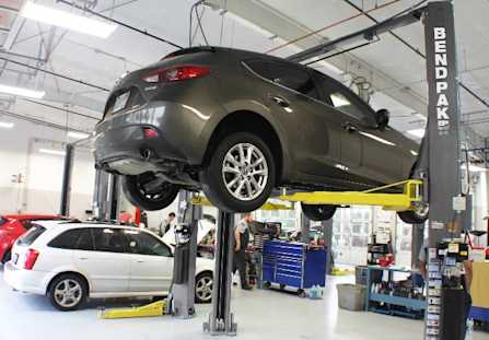 BendPak Two Post Lift Raising SUV in Service Shop