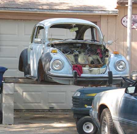 Unsafe DIY Car Lift Using Concrete Blocks in Home Garage