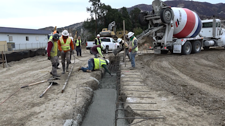 Construction Crew Pouring Concrete Foundation for Industrial Facility