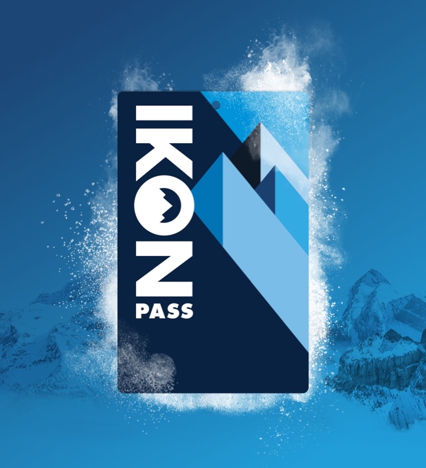 A closeup of an Ikon Pass against a mountain landscape background.