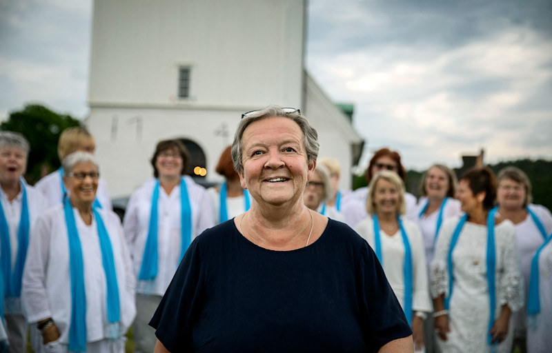Kvinna framför kyrkokör och kyrka