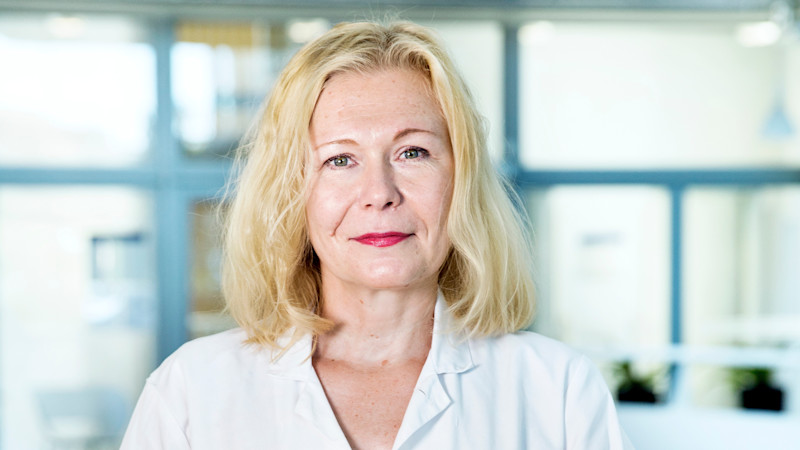 Kvinnlig forskare med rock i labbmiljö