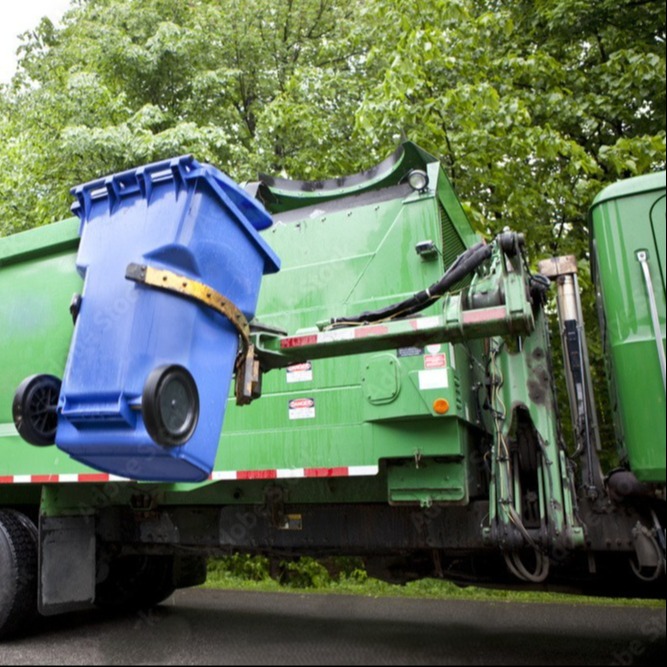 A garbage truck collecting waste along a neighborhood street.