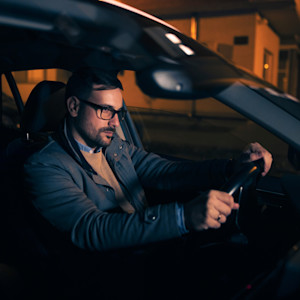 A tired man driving at night.