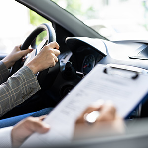 A young woman taking a road test to get her driver's license.