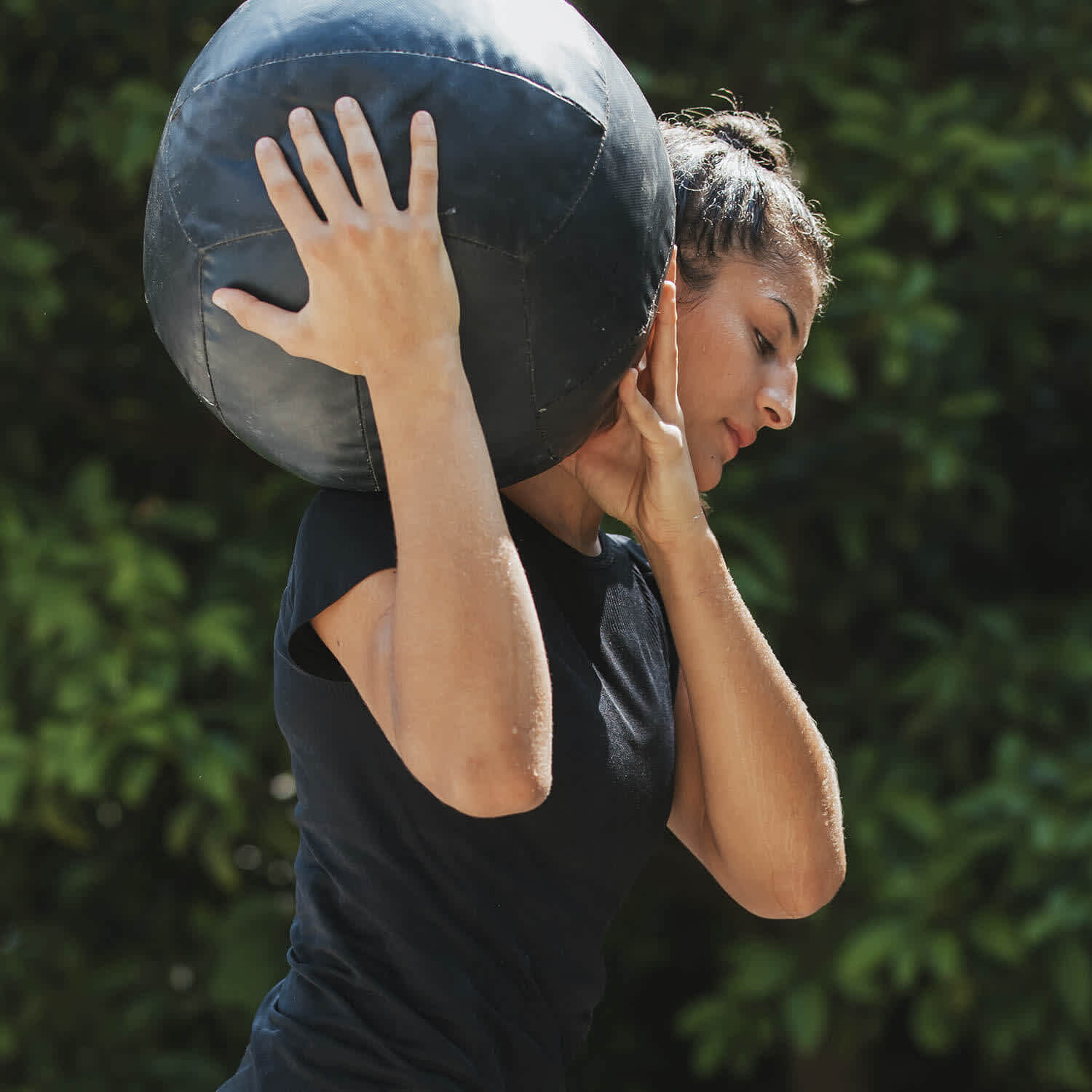 Mulher carrega bola no ombro direito durante treinamento