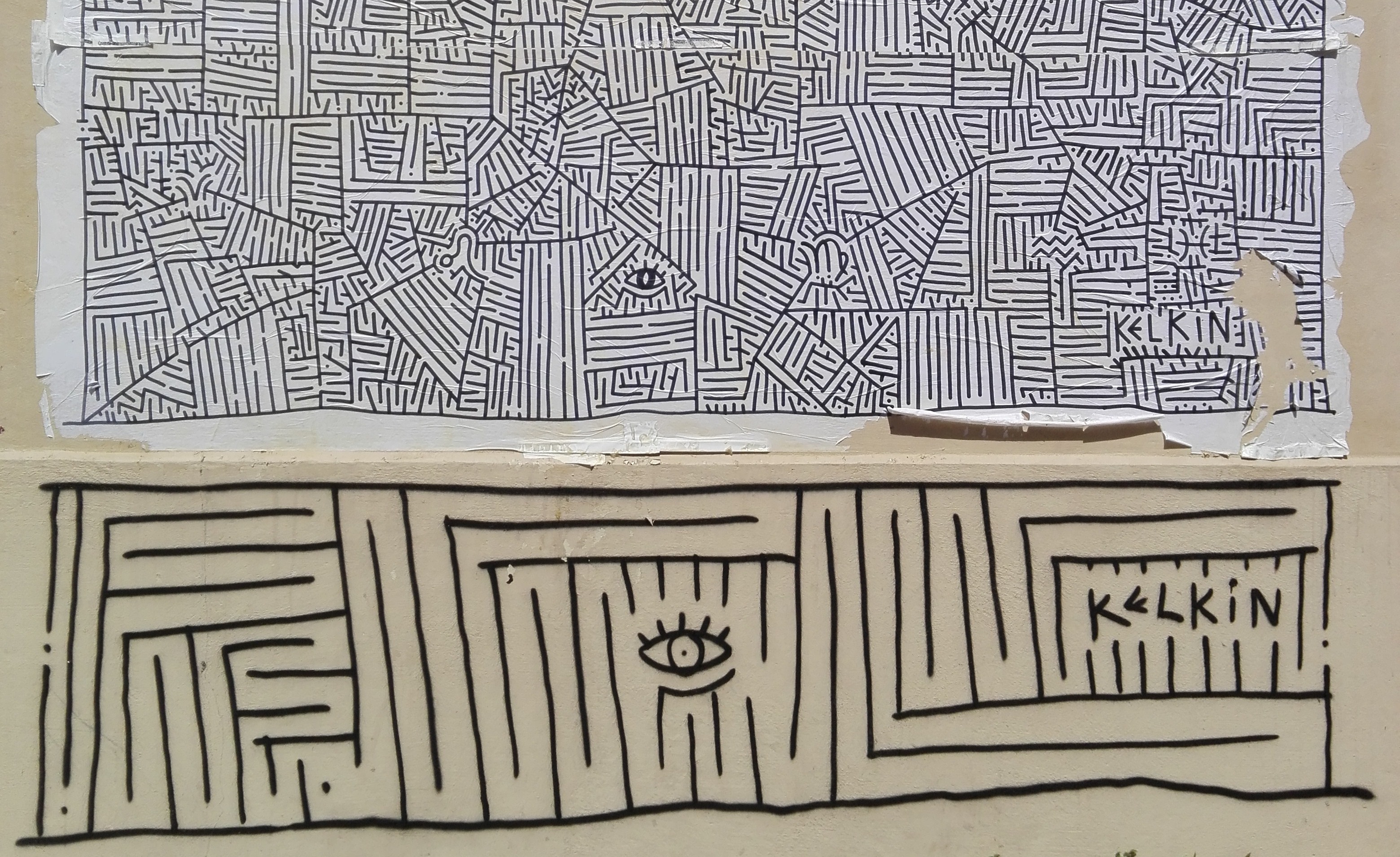 Decoratieve afbeeldingen van een grafitti tekening op een muur in Parijs. De tekening stelt een doolhof voor.