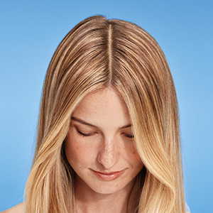 Porträt einer schönen Frau mit blonden Haaren vor blauem Hintergrund