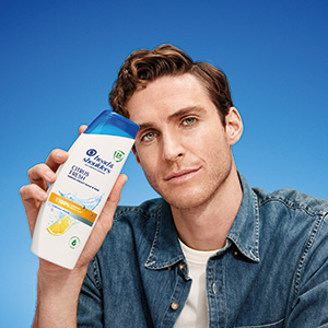Mann präsentiert eine Flasche Head & Shoulders Citrus Fresh Shampoo.