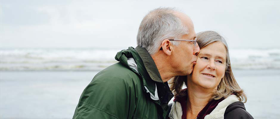 Retired couple embracing on the beach 