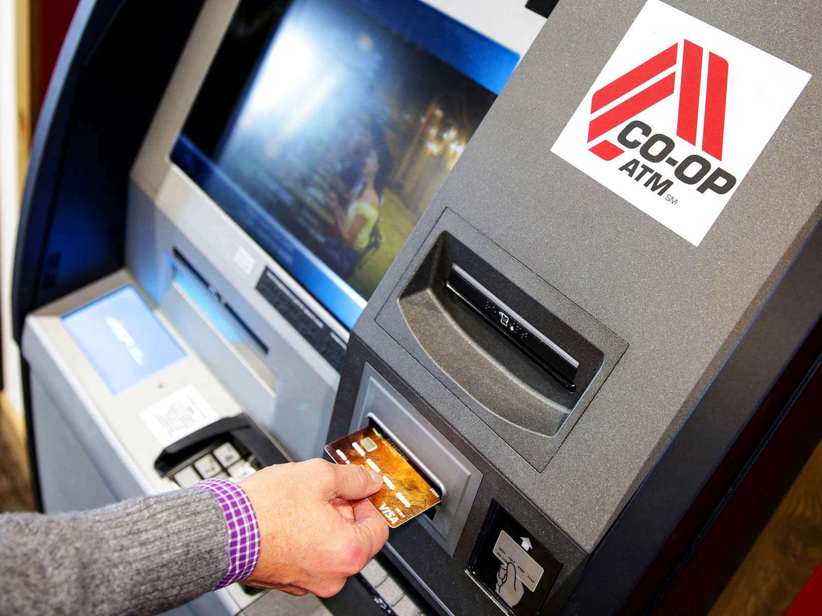 Man inserts bank card into Co-Op ATM