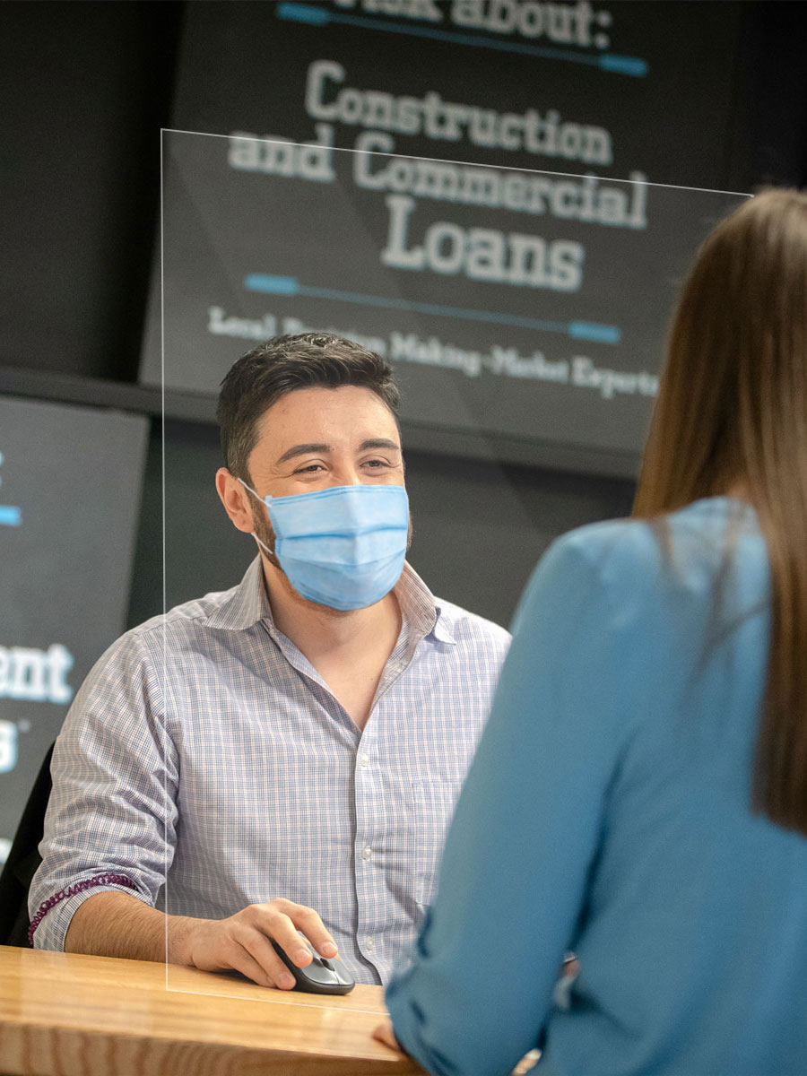 A male teller in a branch helping a customer