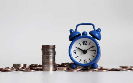 Photo of an alarm clock on a pile of loose change