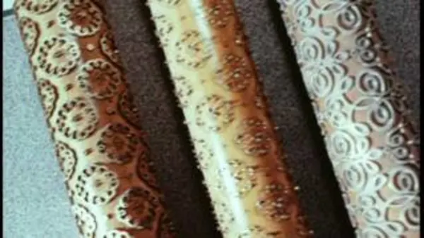 Three scrolls with golden and copper color and intricate designs