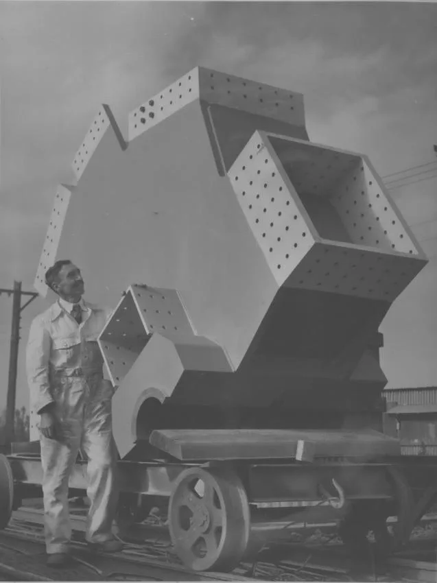 An image of a man and one of the knuckles used in the construction of the Auckland Harbour Bridge.