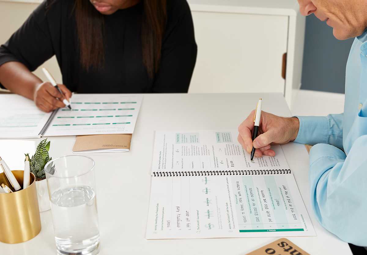 Participants in a classroom filling out workbooks