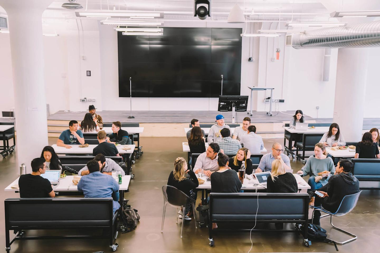Image of many people sitting, working and eating in a cafeteria