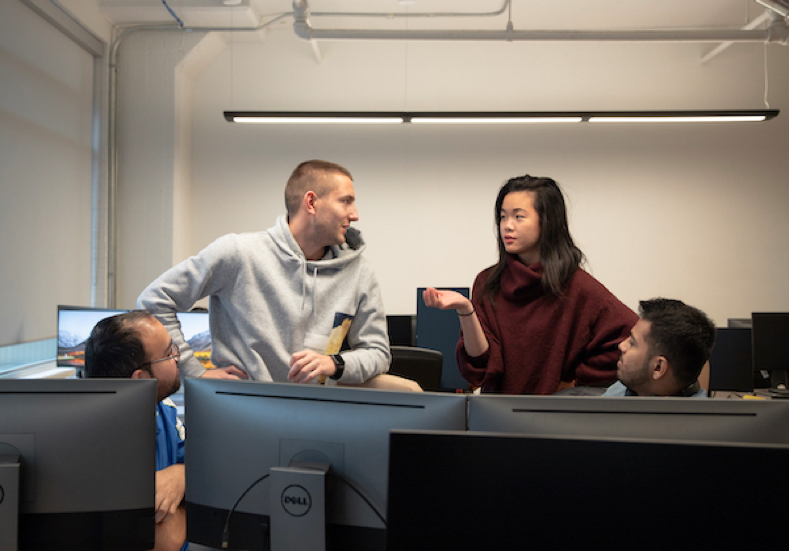 (L to R) Senior Developers Ahmad & Orest working with Product Manager Alison, while Full-stack Developer Fahad listens in.