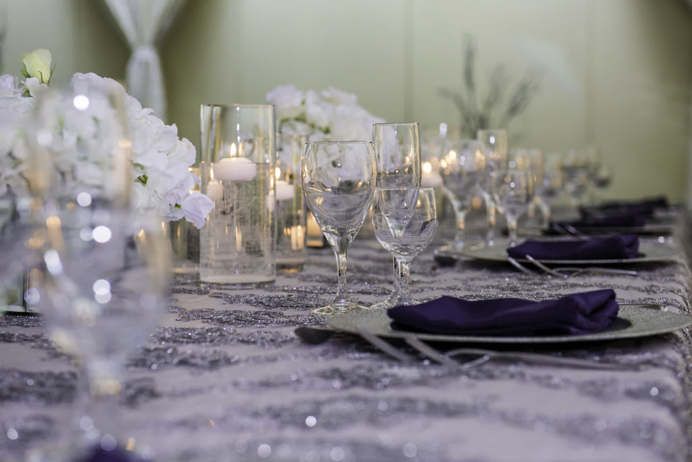 Table setting for a wedding with purple accents and warm glow from candles.