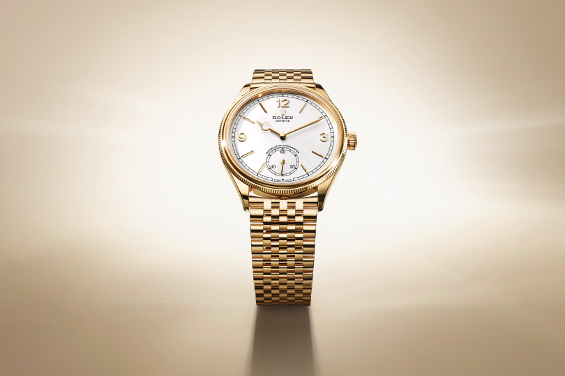 A wristwatch featuring a light blue dial with silver hour markers and hands is displayed against a light blue background. The watch has a brown leather strap and a silver case. 
.