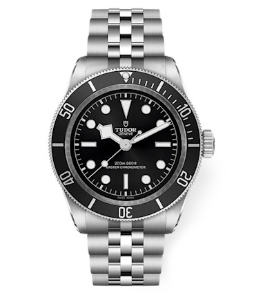 A Tudor wristwatch featuring a black dial, white hour markers, and silver hands. The watch has a stainless steel case and bracelet, a rotating bezel with minute indicators, and a date window at the 3 o'clock position. The brand name is displayed at the top center.