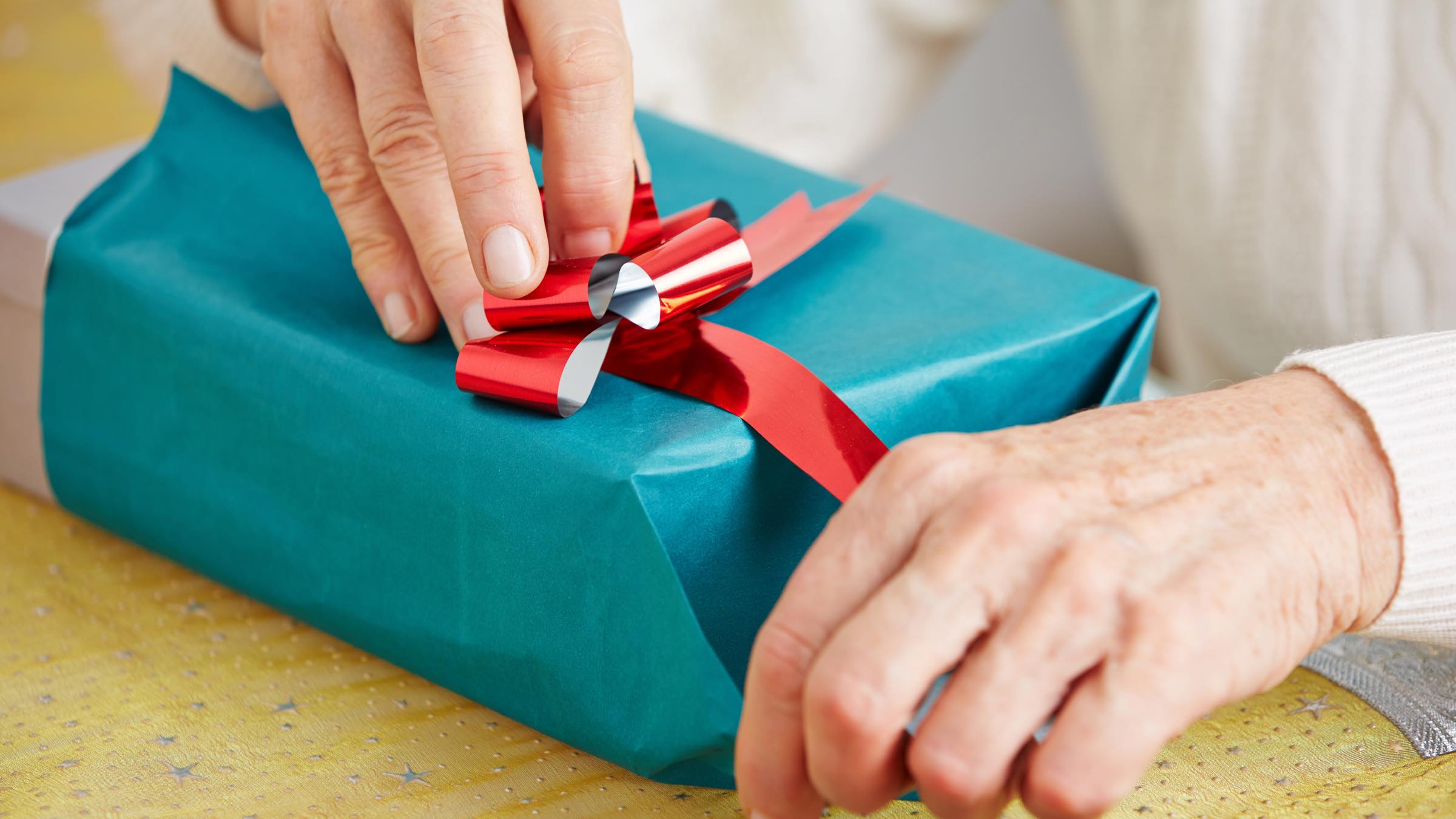 Geschenk für Schwiegermutter wird von Ihr ausgepackt.