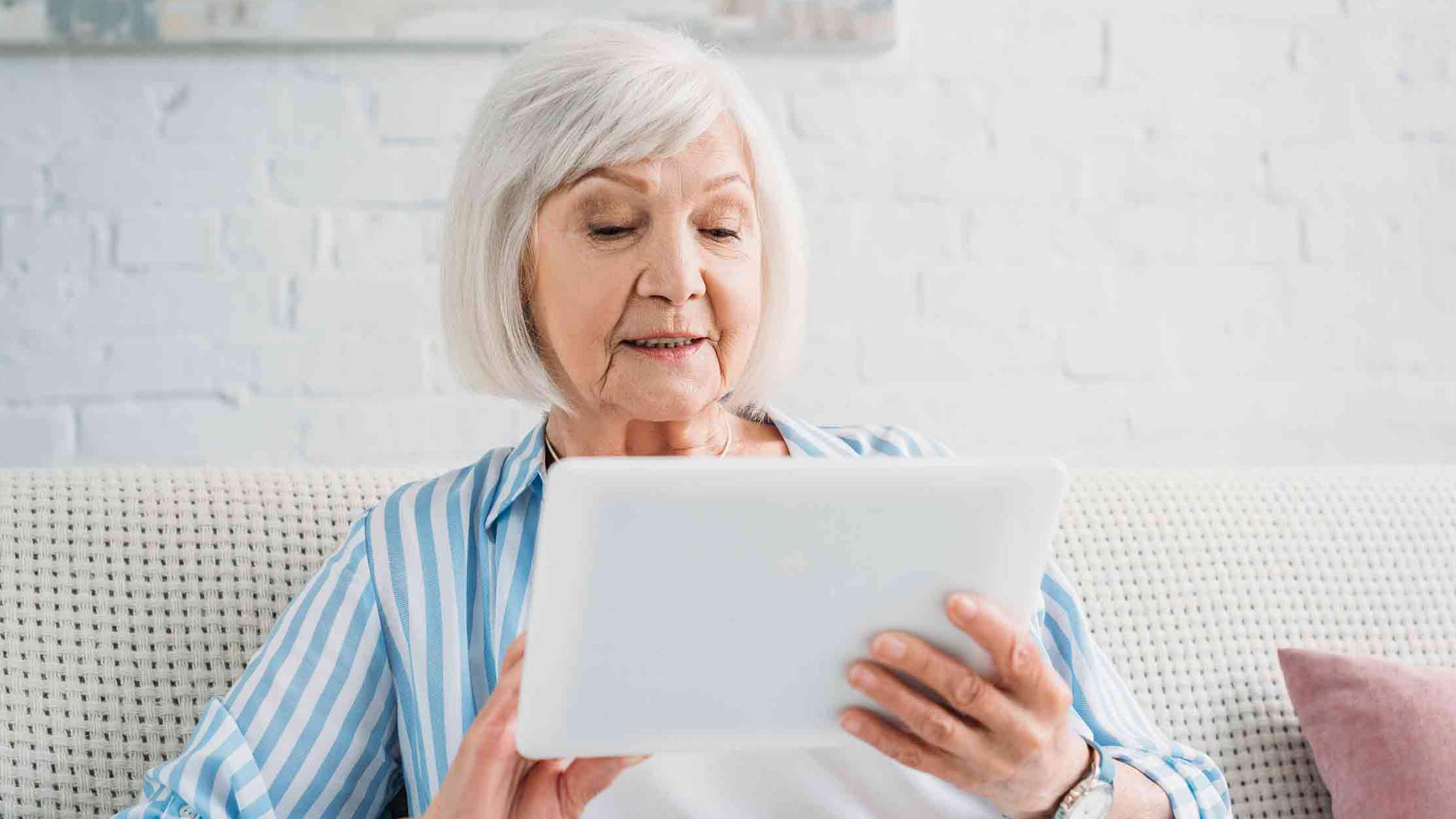 Oma schaut auf Tablet