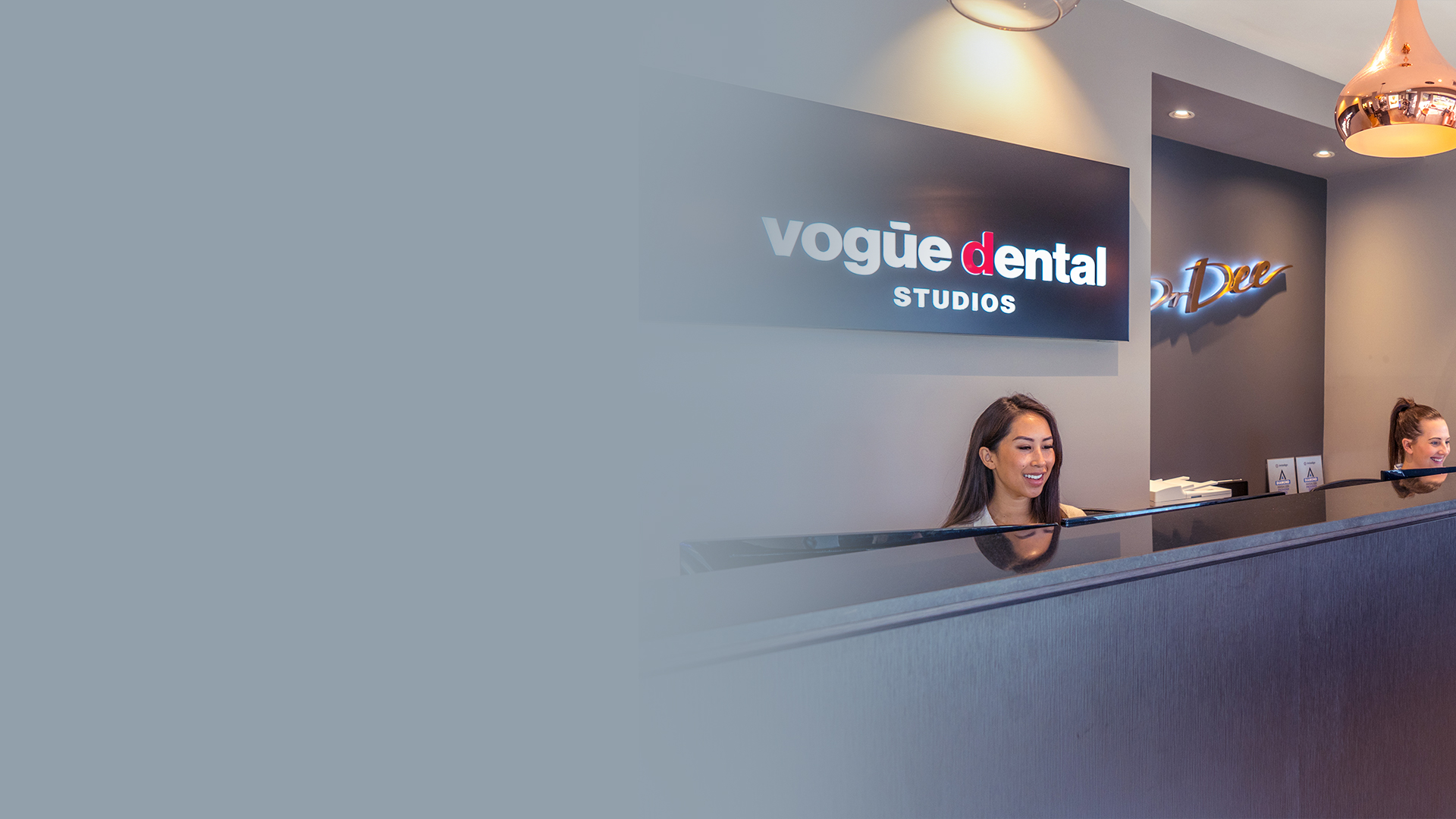 Vogue Dental Studios reception desk with rose gold pendant lights.