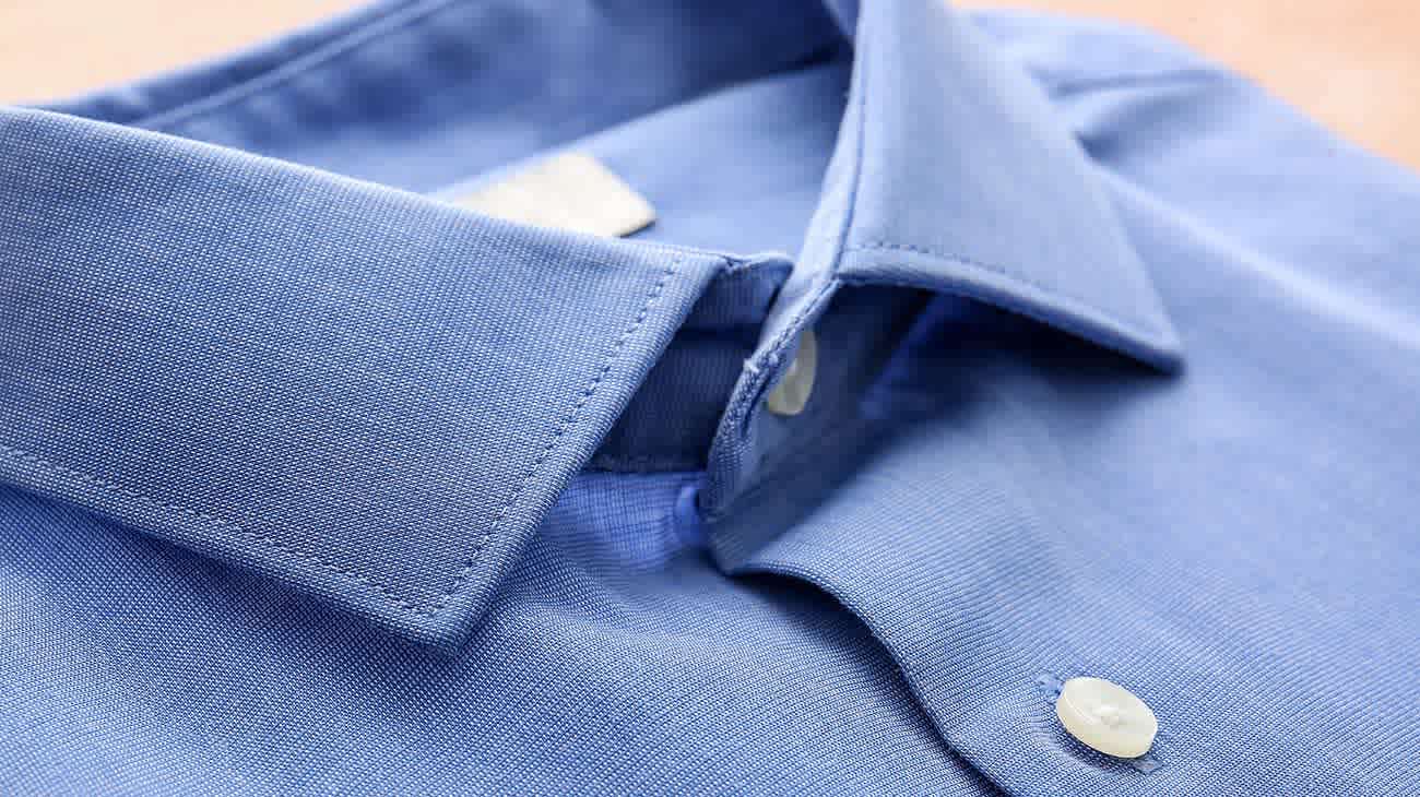 Detalle del cuello de una camisa celeste.