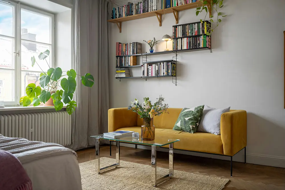 Retroinspirerade inredningsdetaljer och gröna växter lyfter helhetsintrycket i rummet.