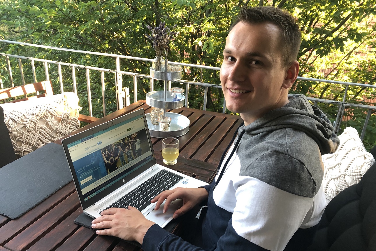 Erik Parthier arbeitet am Laptop auf dem Balkon