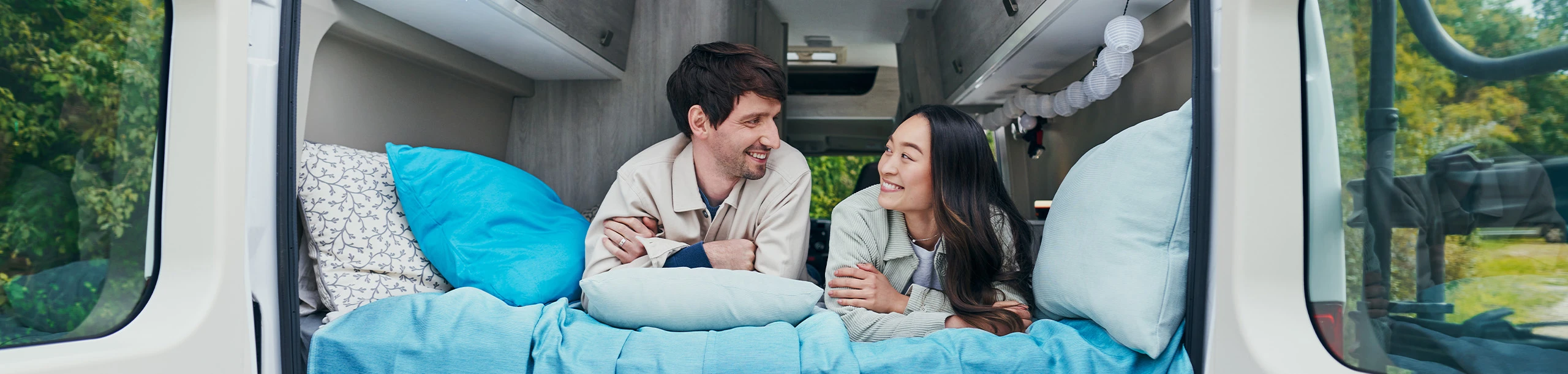 Ein Mann und eine Frau liegen in einem Wohnmobil