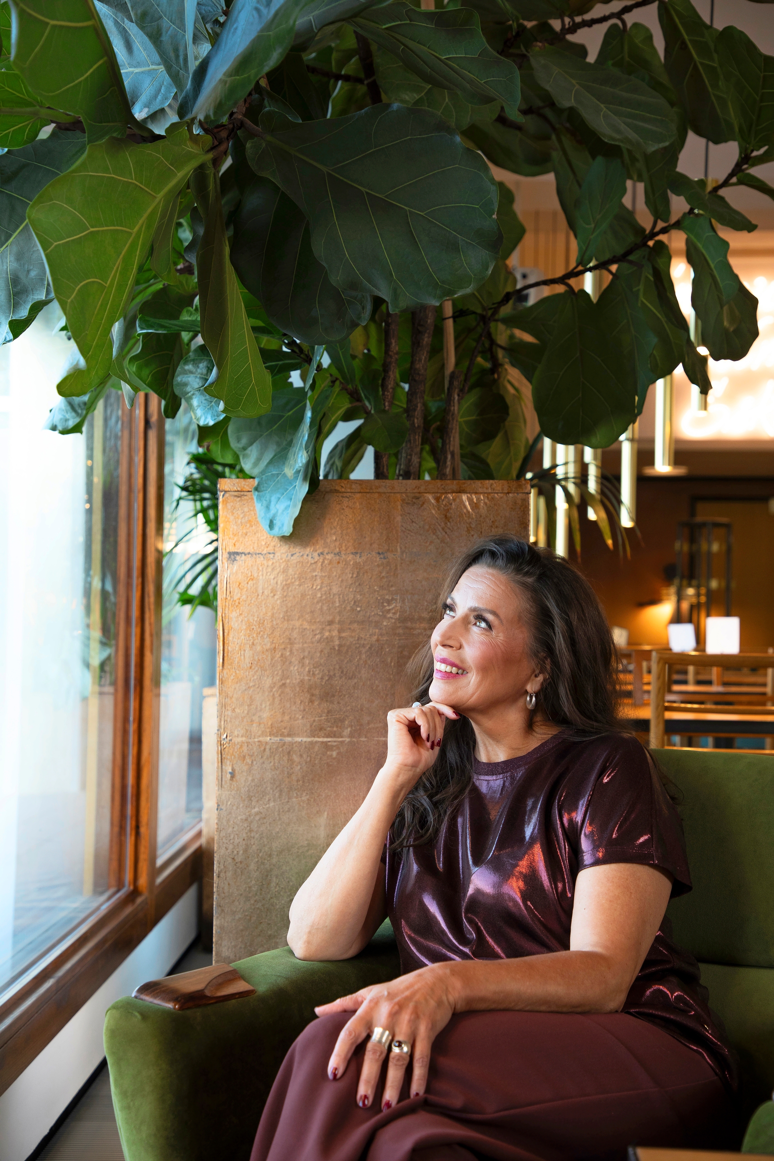 Kristiina istuu ison kasvin edessä