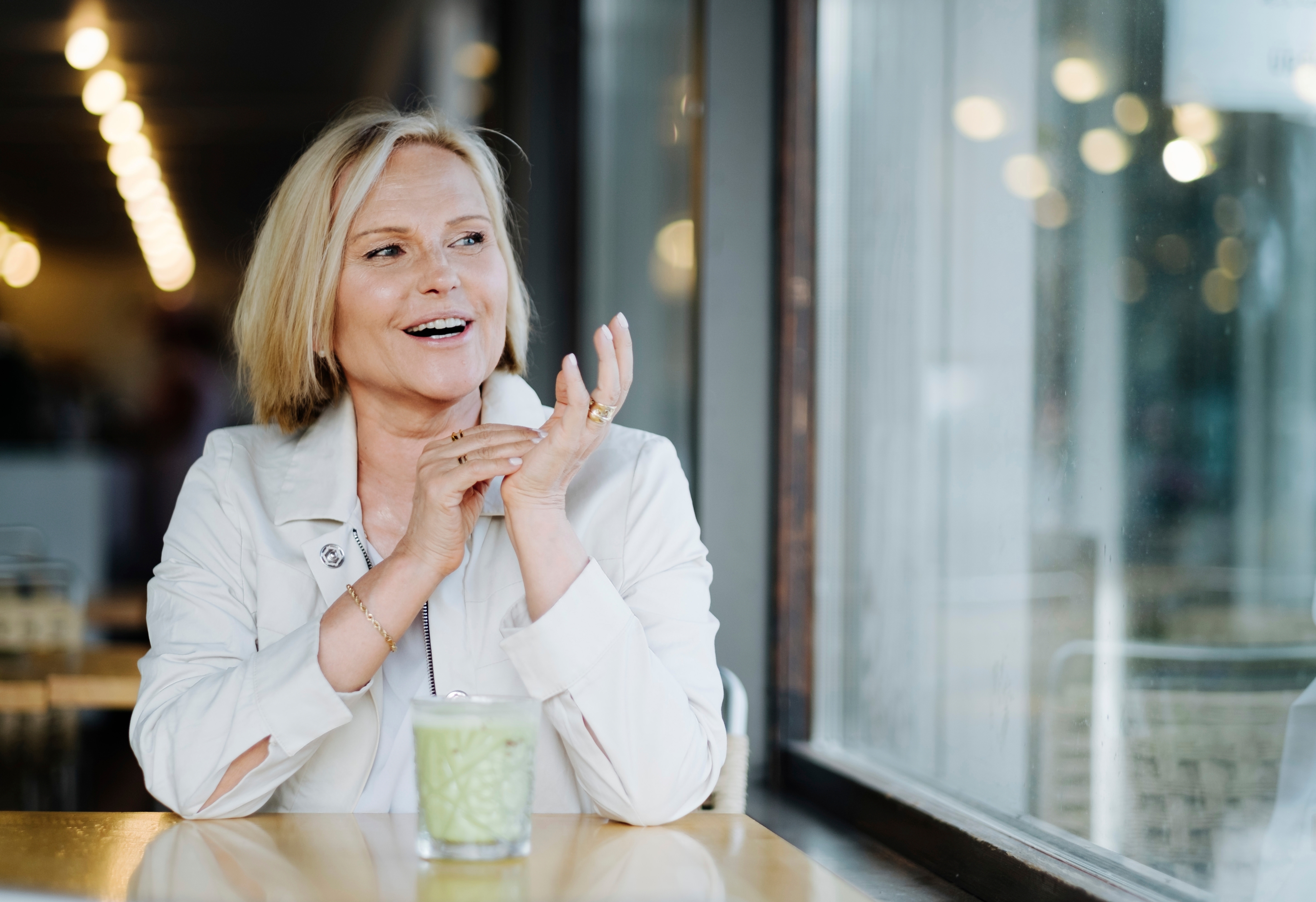 Marja Putkisto kahvilassa katsoo ikkunasta