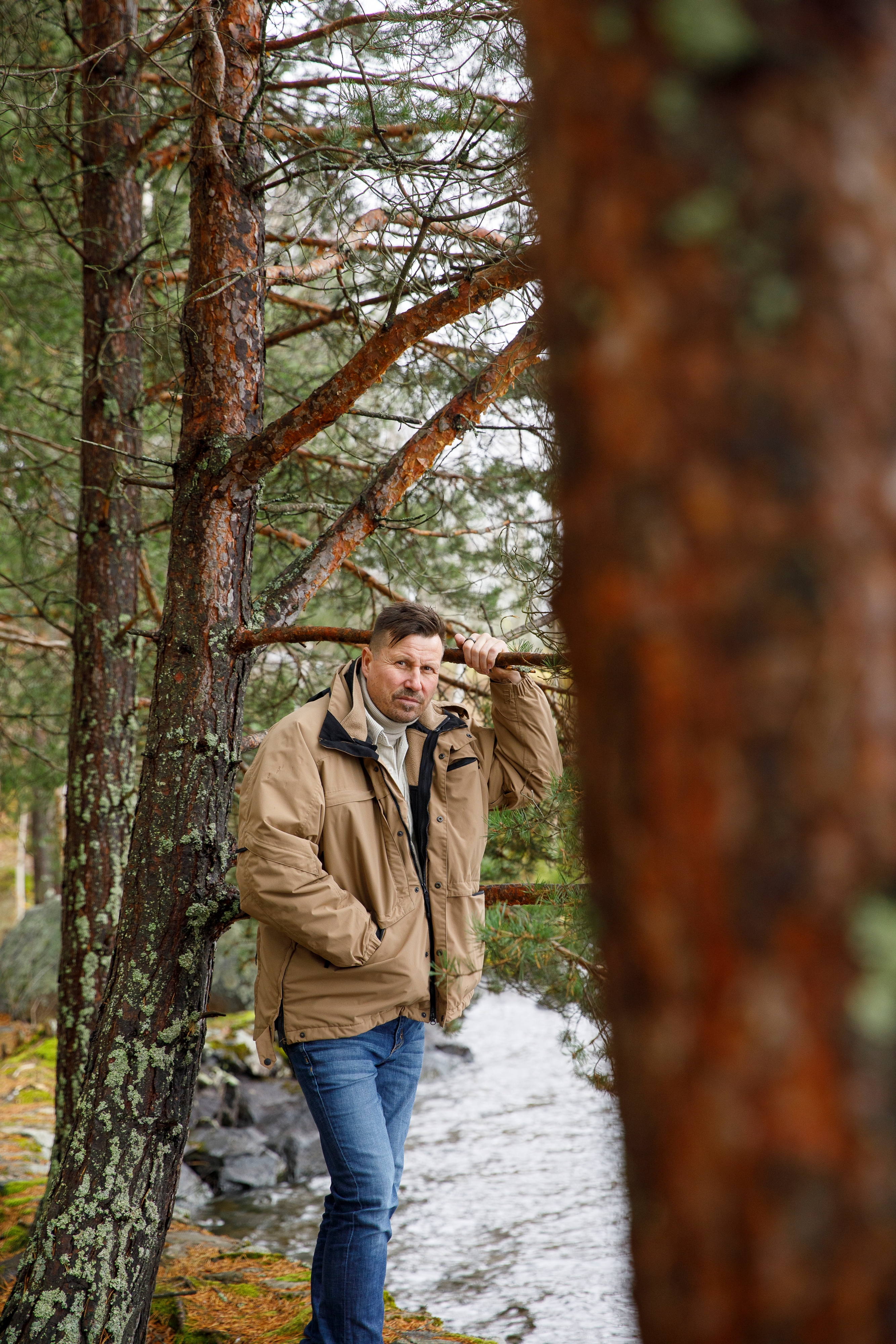 Harri ulkona, pitää kiinni männyn oksasta