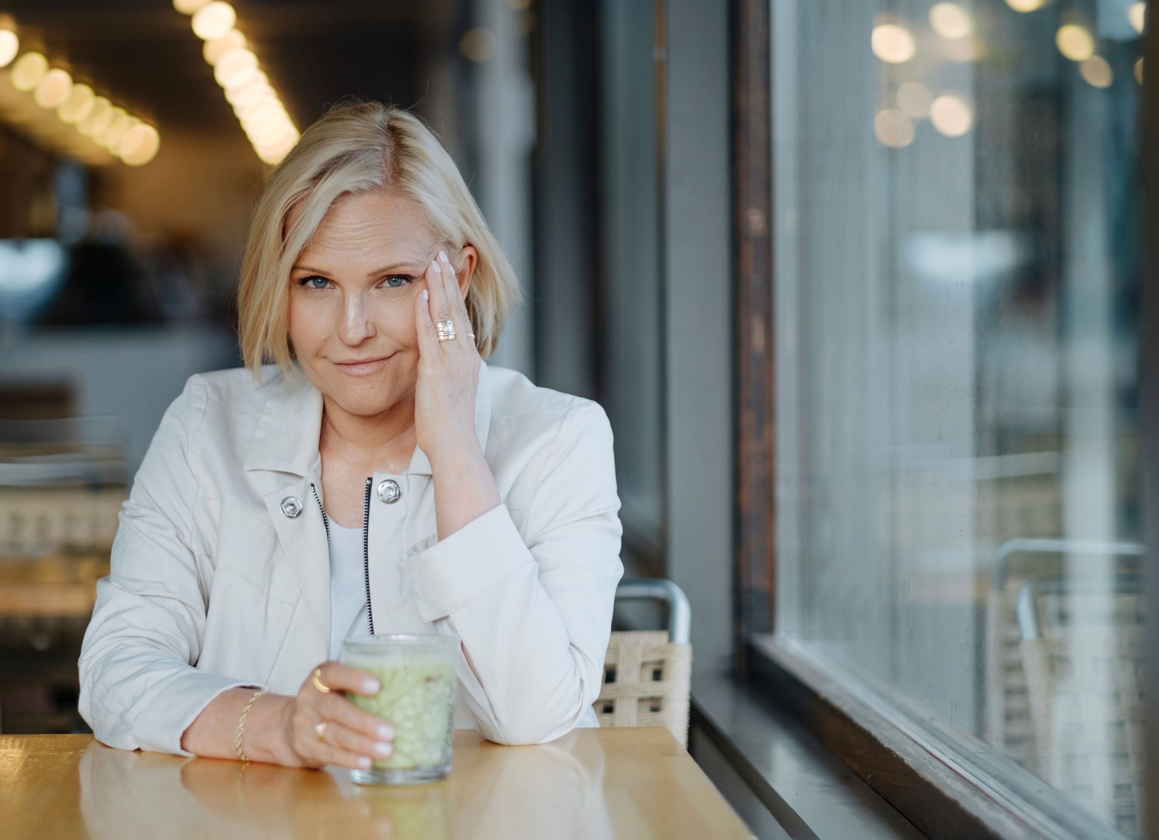 Marja Putkisto kahvilassa kädessään vihersmoothie